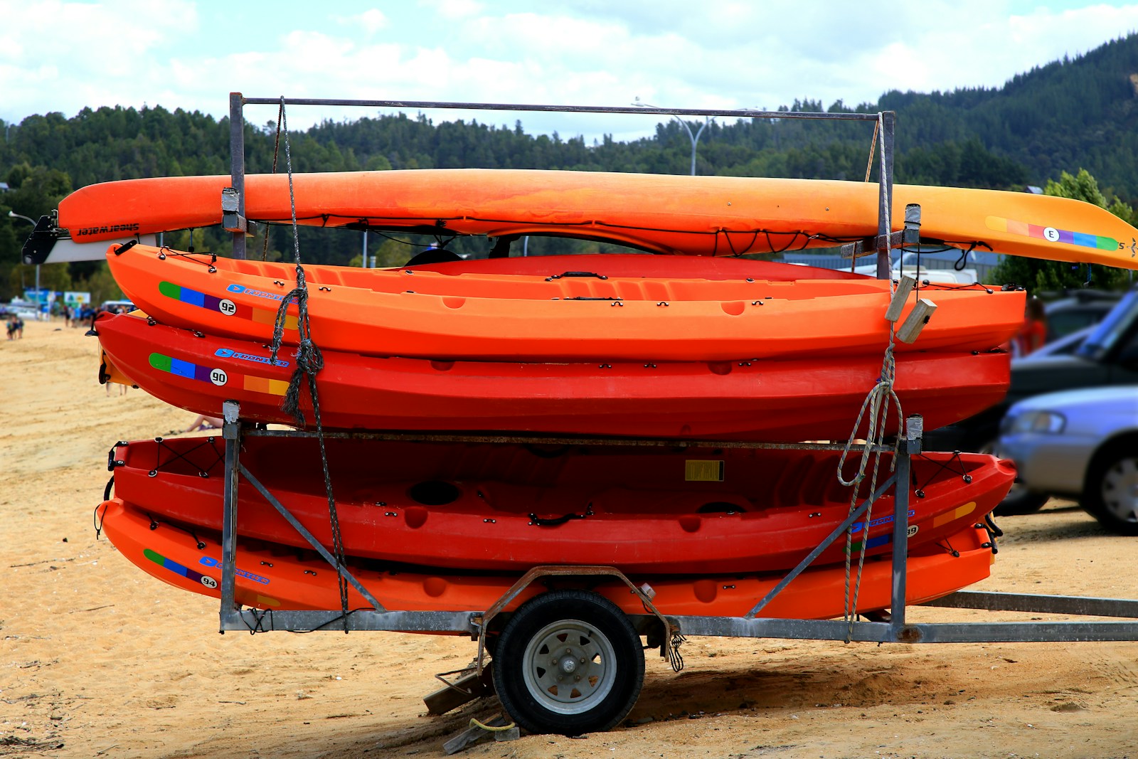 orange and black kayak on brown sand during daytime boat delivery